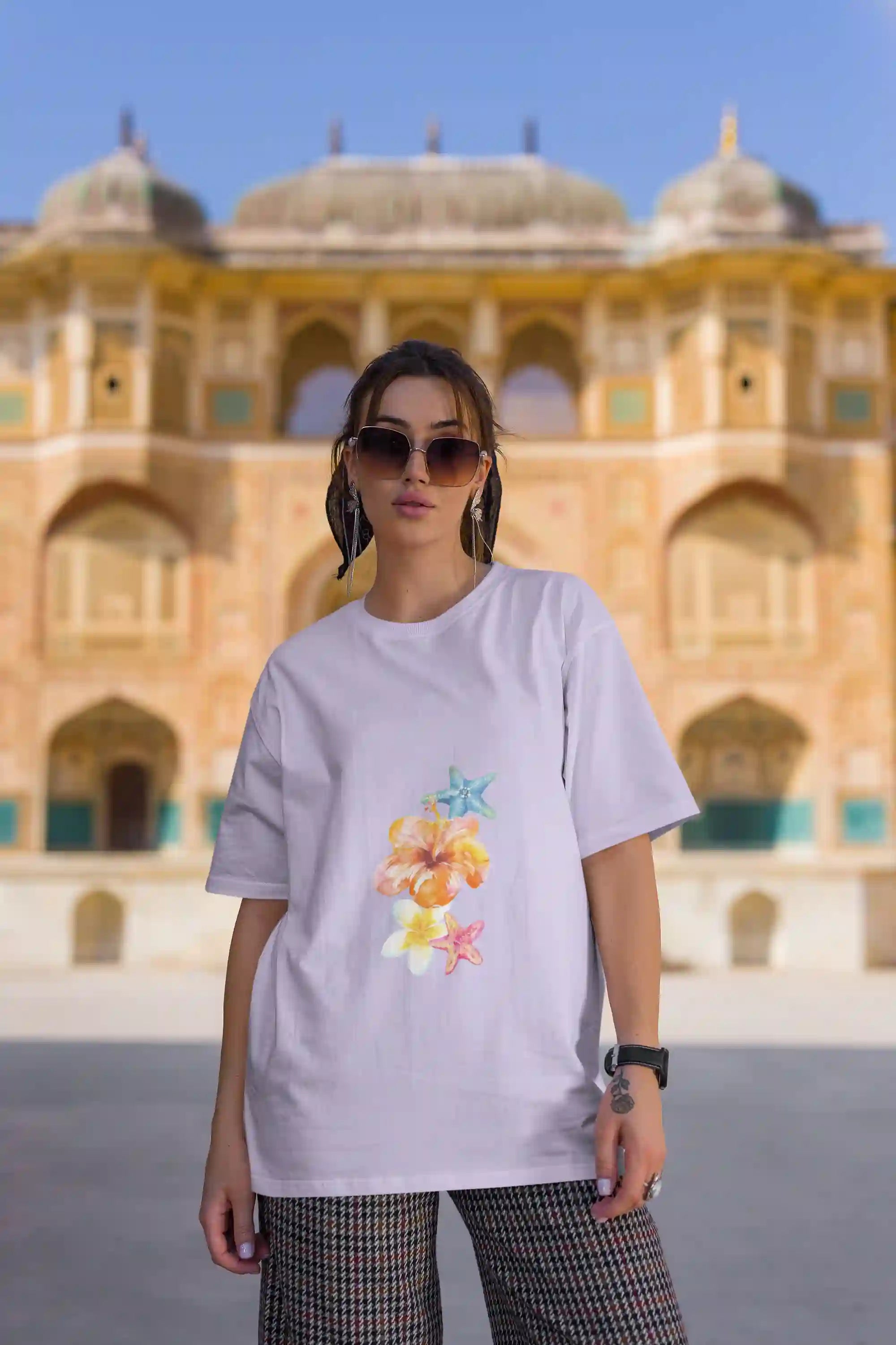Woman wearing Vacation Vibe: The Freshness cotton T-shirt with relaxed fit, perfect for 30+ women, standing stylishly in front of historic building.